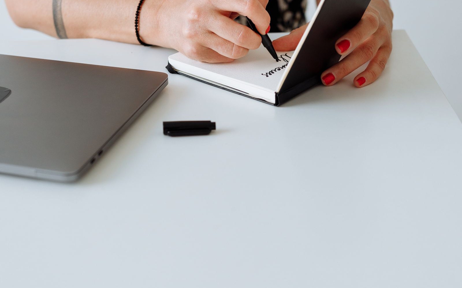 Outreach specialist writing a link building pitch beside a laptop
